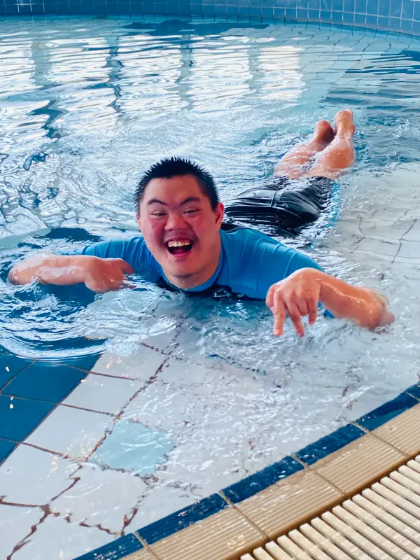 disabled child working on life skills development in a swimming class