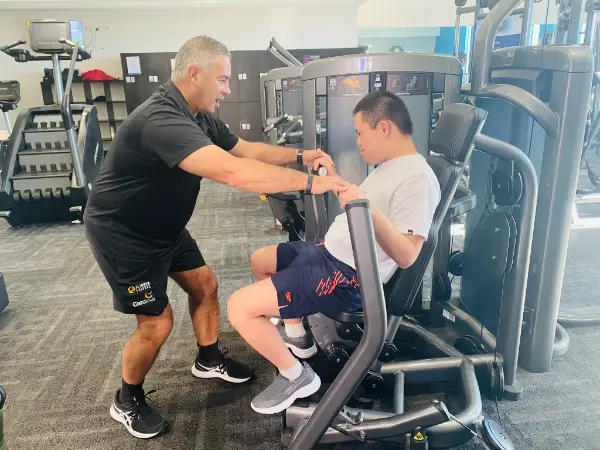 individual support for a child with disability working out in the gym